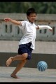 Boy with broken arm playing football in Lenin Park, Hanoi