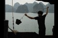 Boatman swings a bucket to clean the deck, Halong Bay