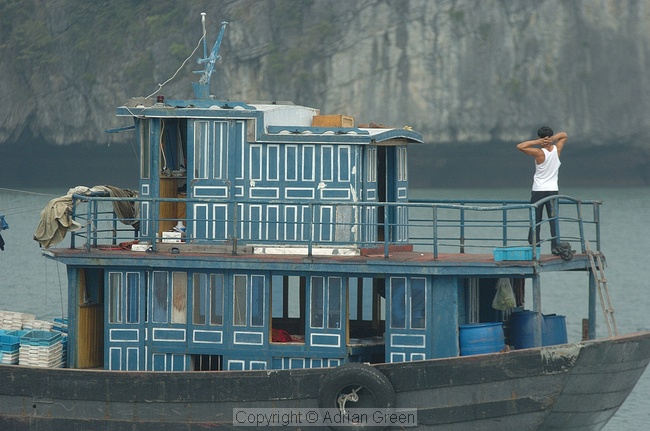Man doing excercises on typical Halong Bay boat