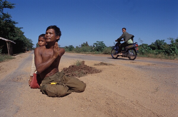 Land mine victim begging on the road with his son, Neak Loeung
