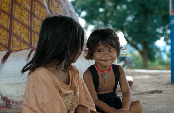 Her eyes say it all. Little girl at the feet of the Reclining Buddha at Phnom Svay