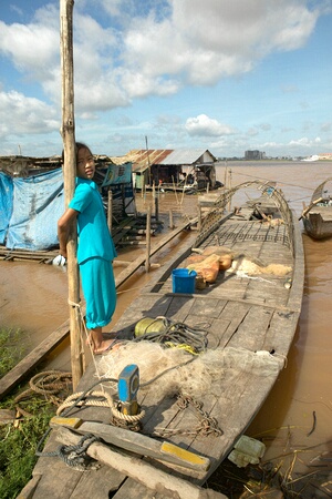 Child on small fishing boat on the Mekong River, Phnom Penh, Cambodia
