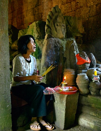 Woman burning (and selling) incense at Ta Prohm, Siem Reap, Cambodia