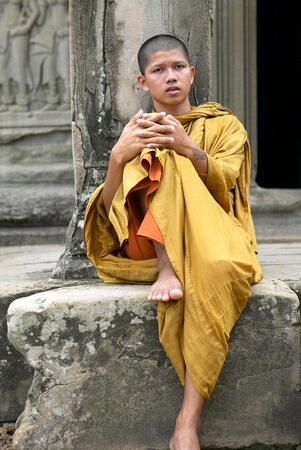 Monk with tatooed arms resting at Angkor Wat, Siem Reap, Cambodia