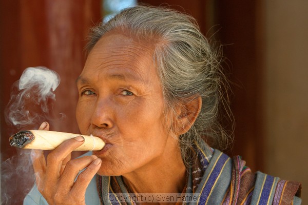 Old woman smoking a giant cheroot, Bagan