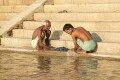 Men share a joke while washing clothes