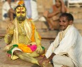 The Ganges river, Varanasi - a "sadhu" - most likely a business proposition rather than a holy mission, gets a foot massage. Even sadhus get sore feet?