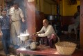 Everyday life in the narrow streets of old Varanasi: the old man has let his milk boil over but seems more amused than upset