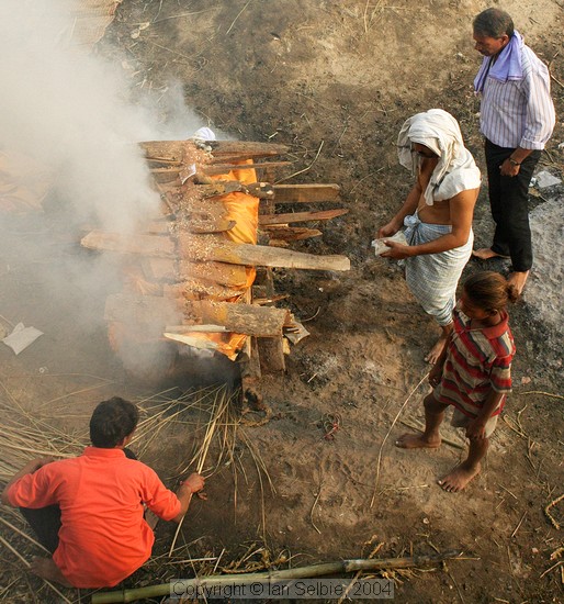 The body is placed on layers of wood, then further layers are piled on top.   Ghee and sandalwood oils are poured to speed the flames,  then the sacred flame is applied