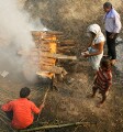 The body is placed on layers of wood, then further layers are piled on top. Ghee and sandalwood oils are poured to speed the flames, then the sacred flame is applied